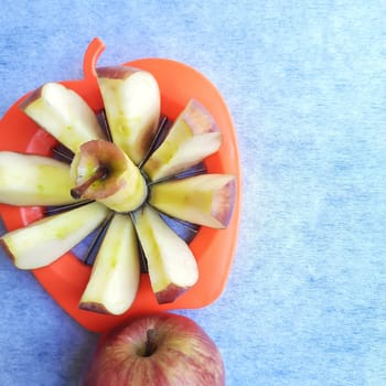 Apple shown beautifully in apple cutter like flower shape and it tempts to eat in white background