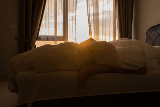 Foot sleeping in the morning at dawn, the girl hangs down the bed. Spy photo. Deep sleep