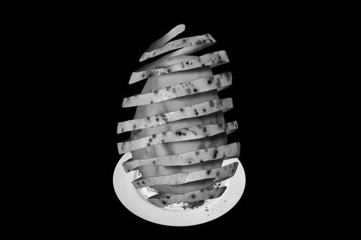 Surreal abstract monochrome composite image of a peeled potato cut out and isolated on a black background