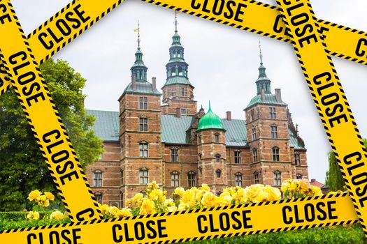 Yellow barrier tape with the words close on the background of the Rosenborg Castle. Rosenborg Castle in Copenhagen, Denmark. Travel industry crisis, Denmark. Rosenborg Castle is quarantined.