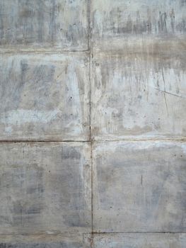 Concrete gray scratched wall of square blocks. Concrete wall texture concrete wallpaper, vertical layout.