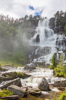 Falls in mountains of Norway in rainy weather. White waterfall. Tvindefossen Waterfall near Voss, Norway.