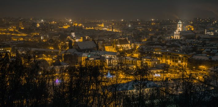 Vilnius Aerial panorama of the Old Town. Vilnius old town panorama at night. Night panorama of the Vilnius Old Town from Hill of Three Crosses, Lithuania. Vilnius winter aerial panorama of Old town.