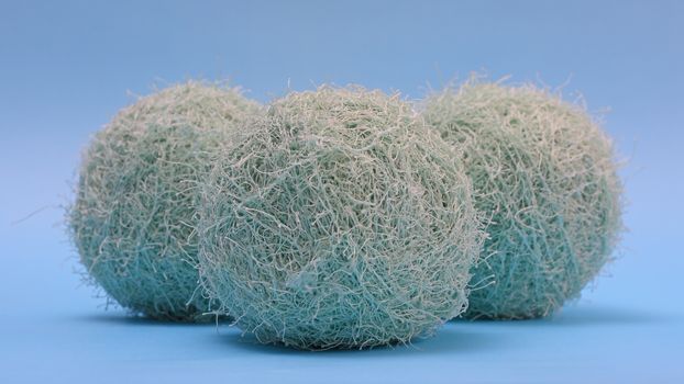 Three fluffy yarns against blue background