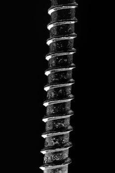 Abstract macro shot of a screw against black