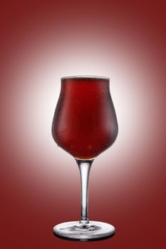 Red ale beer in tulip wineglass isolated on ruby background.