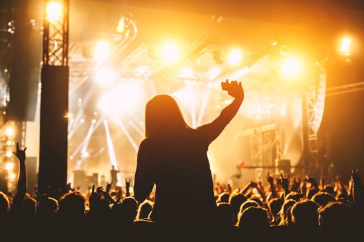 Silhouette of girl with smartphone on music concert.