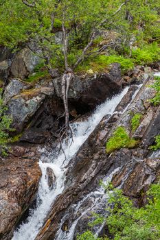 Waterfall in mountains of Norway. Mountain rapid river in the mountains of Norway.