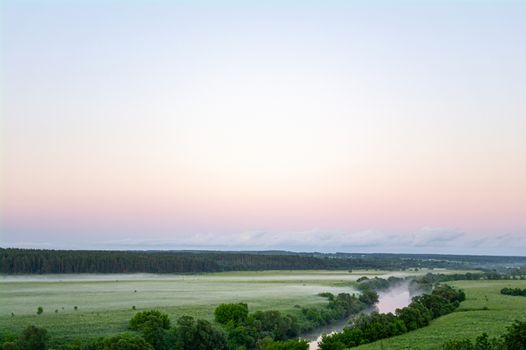 Landscape with river and trees, fields and clouds.