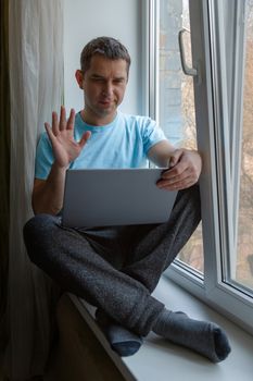 Stay at home concep. Happy young man chatting on tablet, communicating online with family from home during quarantine. Stay home stay safe. Isolation at home to prevent virus epidemic. Safe isolation.