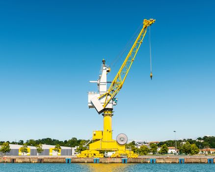 Yellow crane at Bayonne Port on the Adour River in France