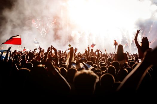 A lot of people with raised hands on a festival music show