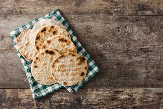 Handmade matzah for Jewish Passover in black plate on wooden table