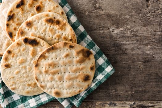 Handmade matzah for Jewish Passover in black plate on wooden table