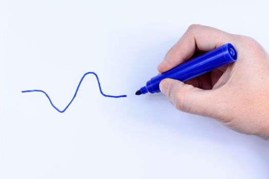 Hand holding a blue  pen drawing a wavey line isolated on white background