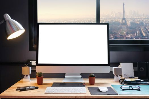 Graphic designer's workspace with cityscape view with a pen tablet, a computer and white background for text