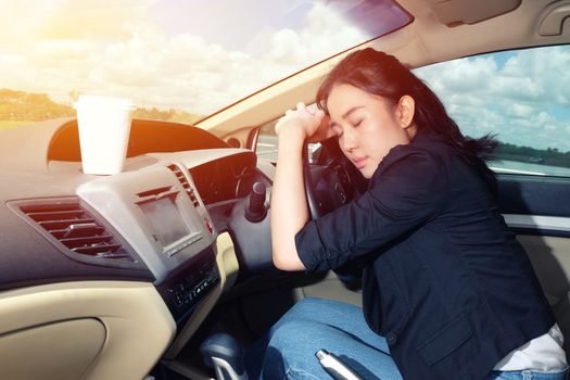 Tired young woman asleep in her car