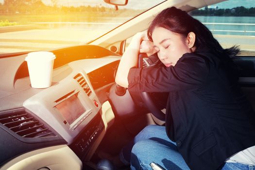 Tired young woman asleep in her car