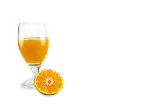 A glass of fresh orange juice with a slice of cut orange fruit placed in front of it. Isolated on white background.