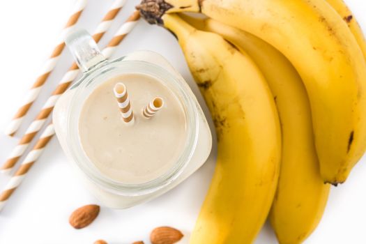 Banana smoothie with almond in jar isolated on white background