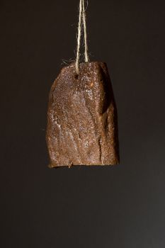 Jerky beef hanging on a rope against a black wall