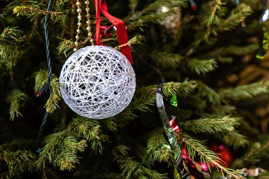 Various colorful Christmas decorations hanged spruce branches.