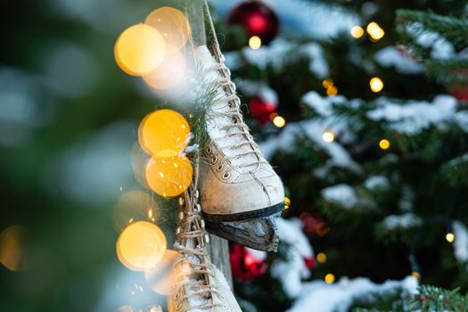 At home, decorated with Christmas decorations, a pair of skates hung. Defocused Christmas tree in the background - image