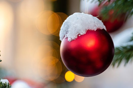 Colorful decorations on snow-covered Christmas tree branches - image