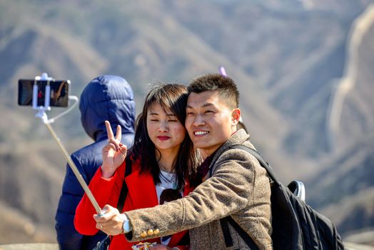 BADALING, CHINA - MARCH  13, 2016: Great Wall of China. Young couple make selfie on the background of the Great Wall of China.