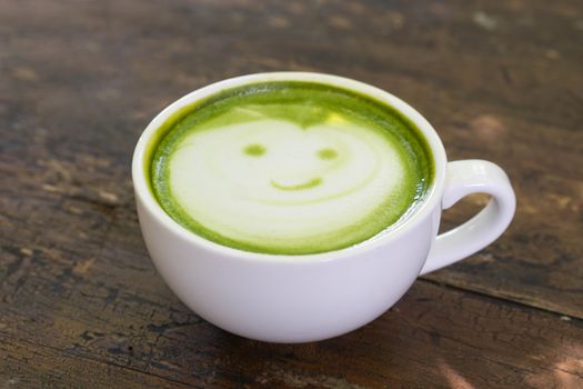 Closeup glass of matcha green tea shape on wood background with vintage color, selective focus