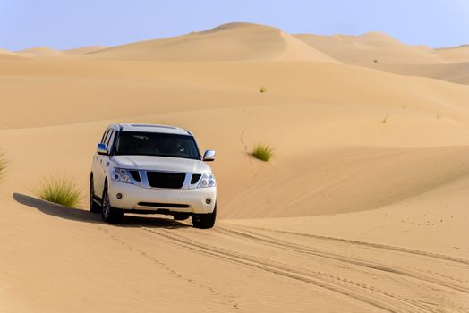 A 4x4 off-roading in the red sand dunes of Dubai Emirates, United Arab Emirates