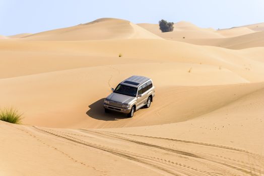 A 4x4 off-roading in the red sand dunes of Dubai Emirates, United Arab Emirates
