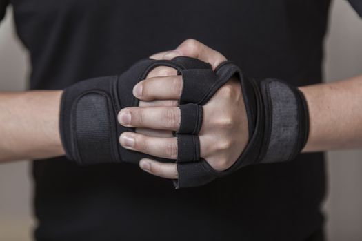 Man's hands put on sports gloves for a gym