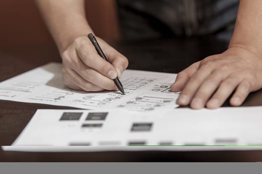 The designer in working process, at a table does sketches by a pencil