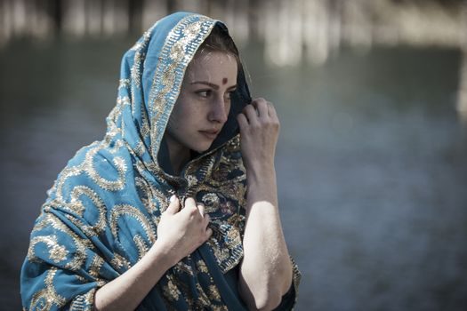 The girl of the European appearance poses in the Indian sari at Kaindy lake