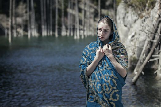 The girl of the European appearance poses in the Indian sari at Kaindy lake