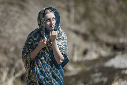 The girl of the European appearance poses in the Indian sari at Kaindy lake