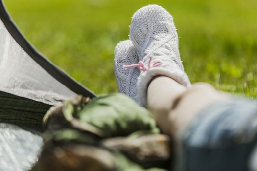 The girl on vacation, sits in tent having put out feet in warm socks