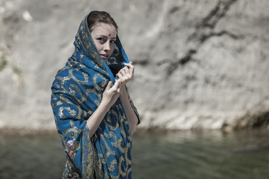 The girl of the European appearance poses in the Indian sari at Kaindy lake