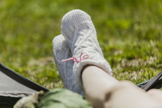 The girl on vacation, sits in tent having put out feet in warm socks