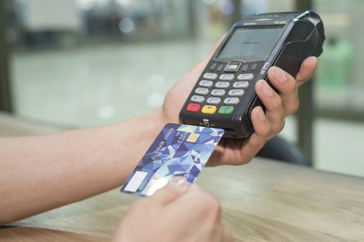 Man's hands carry out payment according to the card by means of the terminal