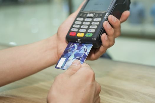 Man's hands carry out payment according to the card by means of the terminal