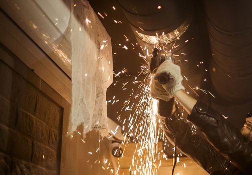 The repairman saws a metal pipe