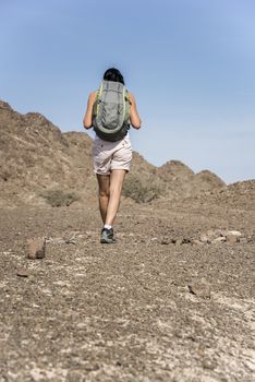 Woman trekking in a Wadi (Dry mountains) of Showka, Ras Al Khaimah, United Arab Emirates