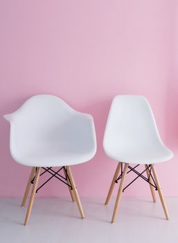 White chair over pink wall in the hipster interior modern room.