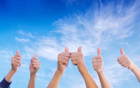 Line of group of human fists giving thumb up - sky background - teamwork  business concept.