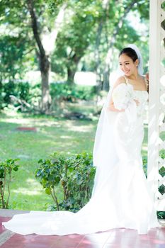 beautiful young woman on wedding day in white dress in the garden. Female portrait in the park.