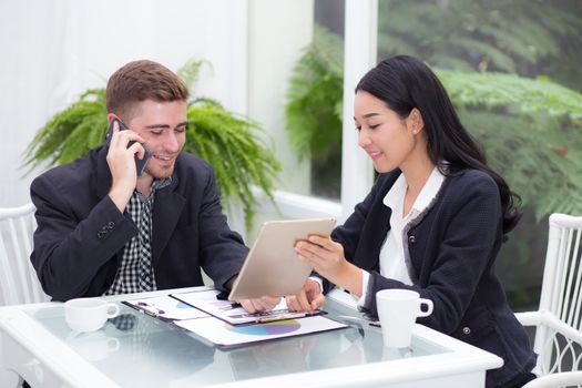 young business people making meeting and looking at tablet for analyzing marketing working at office on desk.