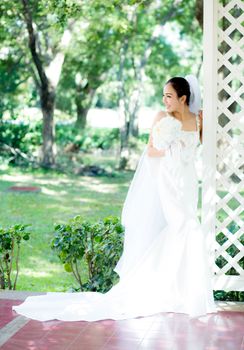 beautiful young woman on wedding day in white dress in the garden. Female portrait in the park.