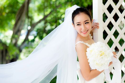 beautiful young woman on wedding day in white dress in the garden. Female portrait in the park - Selective focus.